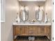 Bathroom featuring a wood vanity with double sinks, white marble countertops, and modern lighting at 4013 Dover Ave, Alpharetta, GA 30009