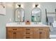 Stylish bathroom featuring a double vanity with marble countertops and modern, arched mirrors at 4013 Dover Ave, Alpharetta, GA 30009