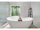 Elegant bathroom featuring a stand-alone tub, a modern shower and frosted windows at 4013 Dover Ave, Alpharetta, GA 30009