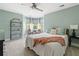 Cozy bedroom featuring soft green walls, a plush bed, and a bay window with natural light, and modern shelving at 4013 Dover Ave, Alpharetta, GA 30009