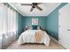 Charming bedroom featuring blue walls, a plush bed, and a window with sheer curtains for soft, natural light at 4013 Dover Ave, Alpharetta, GA 30009