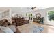 Bright, open-concept living room with hardwood floors, leather sectional, and a view of the staircase and kitchen at 4013 Dover Ave, Alpharetta, GA 30009