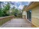 Wooden back deck with glass sliding doors, surrounded by trees, and ample space at 8431 Magnolia Dr, Jonesboro, GA 30238