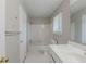 A white bathroom features a sink, vanity, toilet, shower and window at 8431 Magnolia Dr, Jonesboro, GA 30238