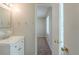 A bathroom with a white cabinet sink, mirror, and doorway to a separate room and walk-in shower at 8431 Magnolia Dr, Jonesboro, GA 30238