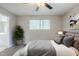 This staged bedroom features neutral walls, carpet, a ceiling fan, and window with natural light at 8431 Magnolia Dr, Jonesboro, GA 30238