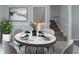 Dining room featuring a round table set for dinner and an open doorway leading to carpeted stairs at 8431 Magnolia Dr, Jonesboro, GA 30238