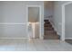 Hallway with tiled flooring and an open doorway, leading to carpeted stairs at 8431 Magnolia Dr, Jonesboro, GA 30238