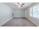 Carpeted living room with neutral walls, ceiling fan, and staircase at 8431 Magnolia Dr, Jonesboro, GA 30238
