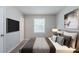 Cozy main bedroom with plush bedding, a window offering natural light, and a mounted flat screen tv at 8431 Magnolia Dr, Jonesboro, GA 30238