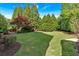 Expansive backyard featuring mature trees, manicured lawn, and a secluded seating area at 3265 Belmont Glen Se Dr, Marietta, GA 30067