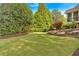 Lush backyard with a well-manicured lawn, mature trees, and a relaxing outdoor seating area at 3265 Belmont Glen Se Dr, Marietta, GA 30067