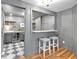 Home bar area showcases wine fridge, modern cabinets, and seating for entertaining guests at 3265 Belmont Glen Se Dr, Marietta, GA 30067