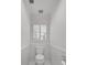 A clean, well-lit, tiled half-bathroom with toilet and window with blinds at 3265 Belmont Glen Se Dr, Marietta, GA 30067