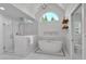 Bright bathroom featuring a soaking tub, glass shower, and a large arched window offering natural light at 3265 Belmont Glen Se Dr, Marietta, GA 30067