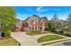 Charming two-story red brick home with a well-manicured lawn and a circular driveway at 3265 Belmont Glen Se Dr, Marietta, GA 30067