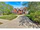Elegant red brick home with a circular driveway and a well-maintained lawn at 3265 Belmont Glen Se Dr, Marietta, GA 30067