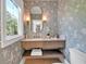 Chic powder room featuring designer wallpaper, a floating vanity, and stylish lighting fixtures at 3265 Belmont Glen Se Dr, Marietta, GA 30067