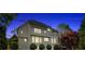 Rear exterior showcasing a spacious backyard, stone patio, and lush landscaping at dusk at 3265 Belmont Glen Se Dr, Marietta, GA 30067