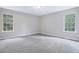 Cozy bedroom with neutral carpet, light gray walls, two windows, and plenty of natural light at 4872 Lewis Rd, Powder Springs, GA 30127