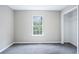 Clean bedroom featuring light gray walls, plush gray carpeting, a window and a closet at 4872 Lewis Rd, Powder Springs, GA 30127