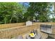 Back deck with outdoor seating and stainless steel grill overlooking fenced in yard with shed at 1835 Hawkins Se St, Smyrna, GA 30080