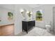 Bright bathroom featuring a double sink vanity, oval mirrors with sconces, marble floors, and large window at 1835 Hawkins Se St, Smyrna, GA 30080