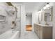 Modern bathroom featuring marble tile, a luxurious soaking tub with a shower, and double sink vanity with elegant fixtures at 1835 Hawkins Se St, Smyrna, GA 30080