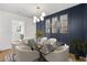 Elegant dining room with a glass top table, modern chandelier, and wainscoting at 1835 Hawkins Se St, Smyrna, GA 30080
