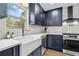 Stylish kitchen with navy blue cabinets, quartz countertops, stainless steel appliances and farmhouse sink at 1835 Hawkins Se St, Smyrna, GA 30080