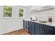 Stylish wet bar featuring blue cabinets, quartz countertop, mini fridge, and wine glasses at 1835 Hawkins Se St, Smyrna, GA 30080