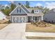 Charming blue home featuring a two-car garage, inviting front porch and manicured lawn at 221 Hickory Bluffs Pkwy, Canton, GA 30114