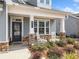 Inviting front porch with stone accents, rocking chairs, and meticulously landscaped garden at 221 Hickory Bluffs Pkwy, Canton, GA 30114
