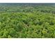 Aerial view showcases the home's wooded seclusion on a lush, green, and private lot at 2361 Mann Rd, Douglasville, GA 30134