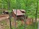 Aerial view of log cabin nestled in the woods, surrounded by lush trees at 2361 Mann Rd, Douglasville, GA 30134