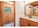 Cabin bathroom featuring wood-paneled walls, wood vanity, and mirror at 2361 Mann Rd, Douglasville, GA 30134