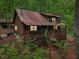 Charming log cabin nestled in a wooded setting with a metal roof and inviting front porch at 2361 Mann Rd, Douglasville, GA 30134