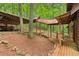 Scenic log cabin with stone accents, covered walkway and open-air garage amidst lush greenery at 2361 Mann Rd, Douglasville, GA 30134