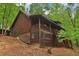 Log cabin exterior featuring a covered porch and natural landscaping at 2361 Mann Rd, Douglasville, GA 30134