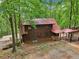Back of cozy log cabin with covered area and lush surroundings at 2361 Mann Rd, Douglasville, GA 30134
