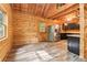 Rustic cabin kitchen featuring wood-paneled walls, wood floors, and stainless steel refrigerator at 2361 Mann Rd, Douglasville, GA 30134
