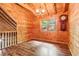 Rustic cabin living room features wood-paneled walls, wood floors, and staircase at 2361 Mann Rd, Douglasville, GA 30134