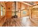 Cabin living room features stone fireplace, wood-paneled walls, and staircase at 2361 Mann Rd, Douglasville, GA 30134
