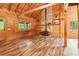 Spacious living room featuring wood paneling, wood flooring, stone fireplace, and vaulted ceilings at 2361 Mann Rd, Douglasville, GA 30134