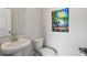 Modern bathroom with a pedestal sink, toilet, and decorative artwork at 4389 Treadle Sw Rd, Mableton, GA 30126