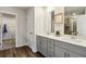 Bright bathroom with double vanity, gray cabinets, and a walk-in closet at 4389 Treadle Sw Rd, Mableton, GA 30126
