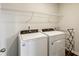 Clean laundry room with white washer and dryer, and wire shelving at 4389 Treadle Sw Rd, Mableton, GA 30126
