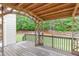 This is a back deck with a wooden pergola and a view of the green lawn and trees at 1342 Winborn Nw Cir, Kennesaw, GA 30152