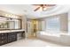 Bright bathroom featuring a soaking tub, glass enclosed shower, and a vanity with dark wood cabinets at 1342 Winborn Nw Cir, Kennesaw, GA 30152