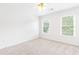 A clean and bright bedroom with plush neutral carpet and natural light from two windows at 1342 Winborn Nw Cir, Kennesaw, GA 30152